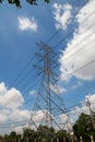 Mast electrical power line against cloud and blue sky.