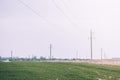 Mast electrical power line in field on a sunny day. High voltage pole