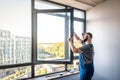 Master adjusting pvc windows with screwdriver. Installation of plastic windows repair and maintenance concept Royalty Free Stock Photo