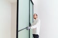 master adjusts sliding doors of wardrobe made of metal and glass. Royalty Free Stock Photo