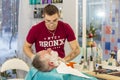 A master applies shaving cream to the beard of an adult man in a hairdressing salon with a shaving brush. Royalty Free Stock Photo