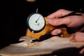 Master artisan luthier working on the creation of a violin. painstaking detailed work on wood.