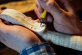 Master artisan luthier working on the creation of a violin. painstaking detailed work on wood.