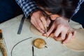 Master artisan luthier working on the creation of a violin. painstaking detailed work on wood.