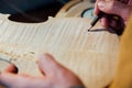 Master artisan luthier working on the creation of a violin. painstaking detailed work on wood.