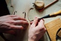 Master artisan luthier working on the creation of a violin. painstaking detailed work on wood.