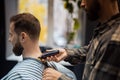 Master in barbershop makes men's haircutting with hair clipper Royalty Free Stock Photo