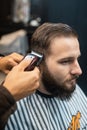 Master in barbershop makes men's haircutting with hair clipper Royalty Free Stock Photo