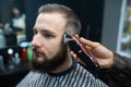 Master in barbershop makes men's haircutting with hair clipper Royalty Free Stock Photo