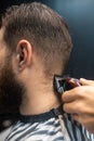 Master in barbershop makes men's haircutting with hair clipper Royalty Free Stock Photo