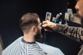 Master in barbershop makes men's haircutting with hair clipper Royalty Free Stock Photo