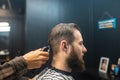 Master in barbershop makes men& x27;s haircutting with hair clipper Royalty Free Stock Photo