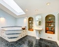 Master bathroom with blue marble tile floor and corner bath tub. Royalty Free Stock Photo