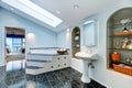 Master bathroom with blue marble tile floor and corner bath tub.