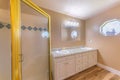 Master bathroom interior with tan walls and toiletries near the hexagon mirror with ornate glass