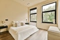 the master bedroom has a large bed and two windows Royalty Free Stock Photo