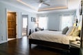 Master bedroom with king size bed and tray ceilings with uplighting and hradwood floors Royalty Free Stock Photo