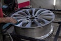 Master body repair man is working on preparing the surface of the aluminum wheel of the car for subsequent painting in the Royalty Free Stock Photo