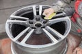 Master body repair man is working on preparing the surface of the aluminum wheel of the car for subsequent painting in the Royalty Free Stock Photo