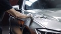 The master in the car service applies a protective armor film to the car body