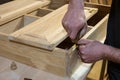 master carpenter works with a hand tool, sets the hinges on the cabinet. Production of handmade wooden furniture.