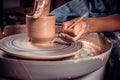 Master-ceramist creates a clay pot on a potter& x27;s wheel. Hands of potter close up. Ancient craft and pottery handmade