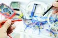 The master checks the electrical circuit in the faulty dental chair with a tester device. Repair of medical equipment