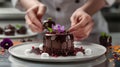 Master chef creating artistic gourmet chocolate dessert with edible flowers. Royalty Free Stock Photo