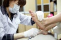 Master chiropody treats sole skin of client.