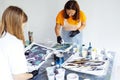 Master class on an Acrylic Fluid Pouring. Young women paint with liquid acrylic in an art workshop. Fluid Art Royalty Free Stock Photo