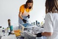 Master class on an Acrylic Fluid Pouring. Young women paint with liquid acrylic in an art workshop Royalty Free Stock Photo