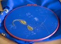 Master class on embroidery.The patterned gold thread on a blue background. Royalty Free Stock Photo