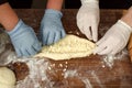 Master class on making Adjarian khachapuri at the national Georgian festival. People`s hands, dough, khachapuri, rolling pin