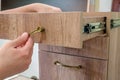 Assembling furniture, installing furniture decorative handles on the furniture facade Royalty Free Stock Photo