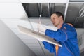 The master connects the lamp to the hidden electrical wiring in the suspended ceiling, close-up Royalty Free Stock Photo