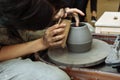The master creates products from gray clay on a potter`s wheel. Girl creates a ceramic vase