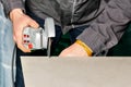 The master cuts the tile with a manual electric grinder with a diamond blade Royalty Free Stock Photo