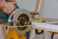 Master cutting hand electric saw cut a piece of wood laminated shelves