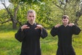 Master and disciple of tai chi practice gymnastics in a blooming garden Royalty Free Stock Photo