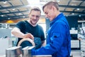 Master discussing a workpiece with his apprentice or trainee Royalty Free Stock Photo