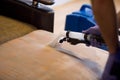 The master does a dry cleaning of the upholstery of a soft sofa using a professional washing vacuum cleaner. process photo