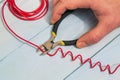 The master electrician cuts the red wire with diagonal cutting pliers. Electronics Repair Idea Royalty Free Stock Photo