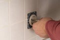 A master electrician mounts an electrical plug on a wall. Vintage electrical outlet