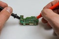 Master engineer tests and repairs microchip with multimeter Royalty Free Stock Photo