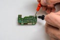 Master engineer tests and repairs microchip with multimeter Royalty Free Stock Photo