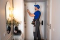 Master furniture maker repairs a closet in the hallway. The carpenter twists the cabinet walls with a screwdriver.