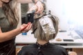 Master hairdresser in beauty salon coloring young woman`s hair using aluminum foil. Royalty Free Stock Photo