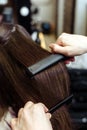 The master hairdresser cuts the ends of the hair of a brunette sitting in a beauty salon. Closeup of hairdresser making haircut to Royalty Free Stock Photo
