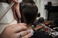 Master hairdresser does hairstyle and style with scissors and comb. Master stacks hair of men in barbershop, hairdresser makes hai