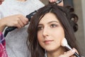 Master inflicts brush powder on the face of the girl, completes the day make-up in a beauty salon. Royalty Free Stock Photo